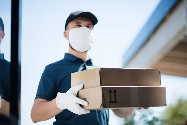 Corriere con maschera per il viso consegna pacco, virus corona e concetto di quarantena . — Foto Stock