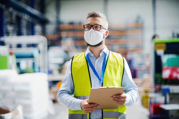 Técnico ou engenheiro com máscara protetora trabalhando na fábrica industrial, andando . — Fotografia de Stock