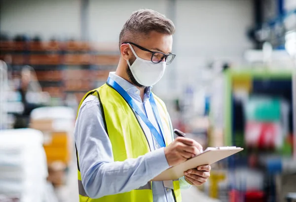 Technicus of ingenieur met beschermende masker werken in industriële fabriek, schrijven. — Stockfoto