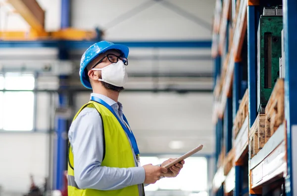 Technicien ou ingénieur avec masque de protection et casque travaillant dans une usine industrielle . — Photo