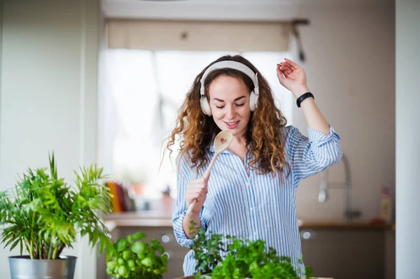 Young woman with headphones relaxing indoors at home. — Stok fotoğraf