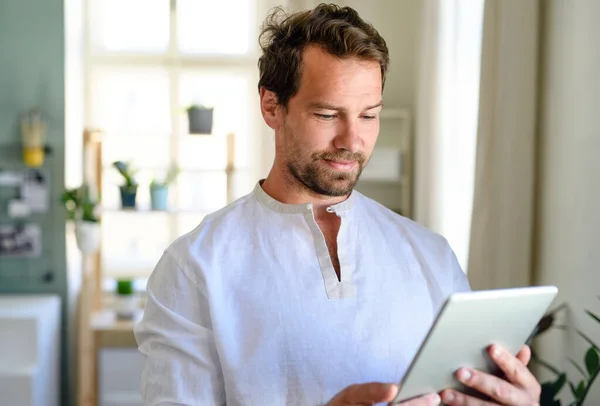 Front view portrait of man using tablet at home. — Stock Photo, Image