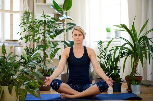 Frontansicht einer jungen Frau, die zu Hause Yoga macht. — Stockfoto