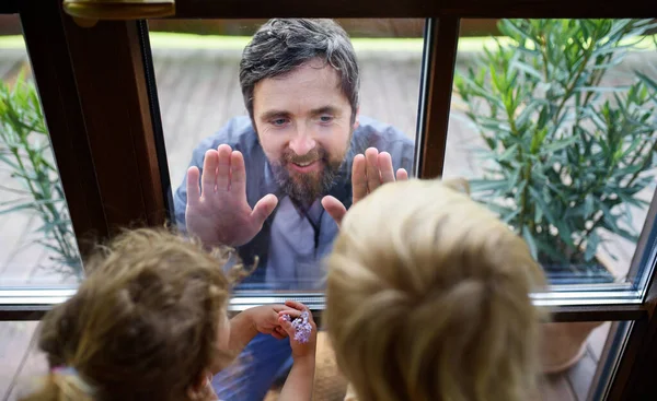 Dokter komt naar kinderen kijken in isolatie, raam glas scheidt ze.. — Stockfoto