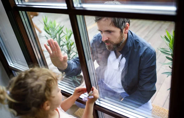 Doctor viniendo a ver a su hija en aislamiento, vidrio de ventana separándolos . — Foto de Stock