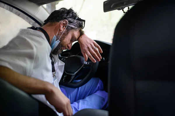 Cansado y agotado médico sentado en el coche después de un turno largo y difícil, durmiendo . —  Fotos de Stock