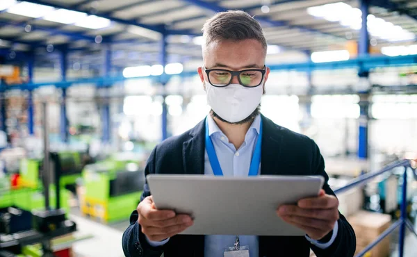 Τεχνικός ή μηχανικός με προστατευτική μάσκα και tablet που εργάζονται σε βιομηχανικό εργοστάσιο. — Φωτογραφία Αρχείου