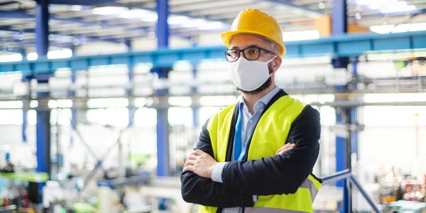 Tekniker eller ingenjör med skyddsmask och hjälm stående i industrifabrik. — Stockfoto