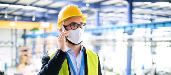 Technik nebo inženýr s ochrannou maskou a helmou pracující v průmyslové továrně. — Stock fotografie