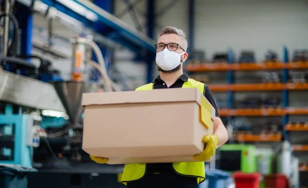 Werknemer met beschermend masker werkzaam in industriële fabriek of magazijn. — Stockfoto