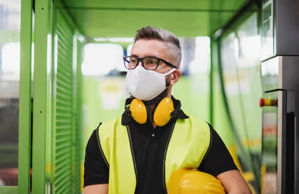 Werknemer met beschermend masker in industriële fabriek of magazijn. — Stockfoto