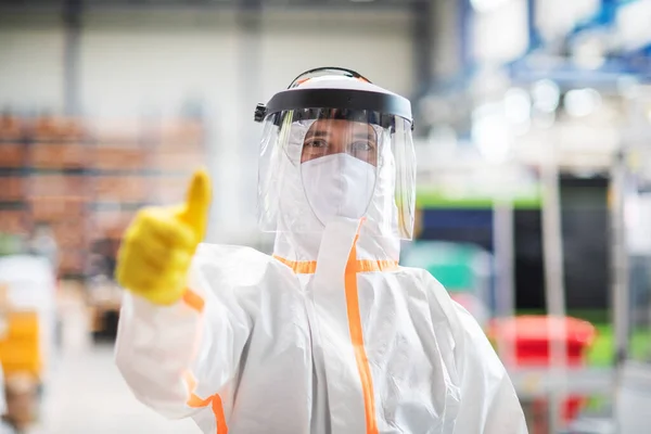 Travailleur avec masque de protection et costume dans l'usine industrielle, pouce levé geste de la main . — Photo