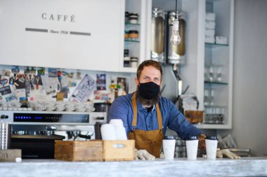 Barista eldivenlerle çalışıyor, karantinadan sonra kafe açık..