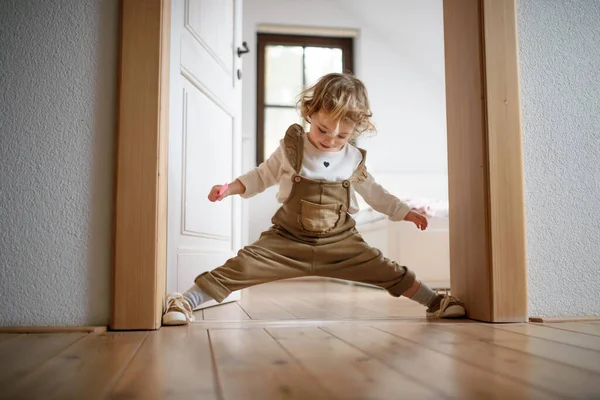 Μικρό κοριτσάκι που στέκεται σε εσωτερικούς χώρους στο σπίτι, διασκεδάζοντας. — Φωτογραφία Αρχείου