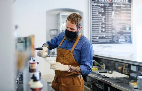 Barista trabajando con guantes, cafetería abierta tras cuarentena de cierre . — Foto de Stock