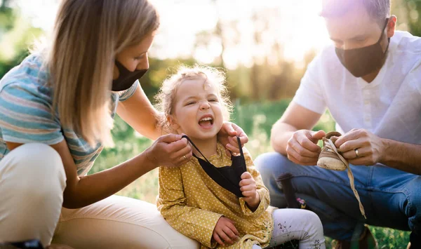 Família com winging pequena filha em viagem na natureza, usando máscaras faciais . — Fotografia de Stock