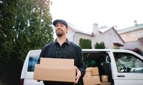 Retrato de entrega mensageiro entregando caixa de encomendas na cidade . — Fotografia de Stock