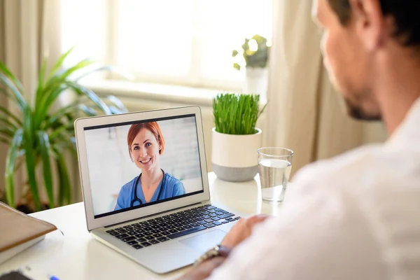 Mężczyzna po rozmowie wideo z lekarzem na laptopie w domu, koncepcja konsultacji online. — Zdjęcie stockowe