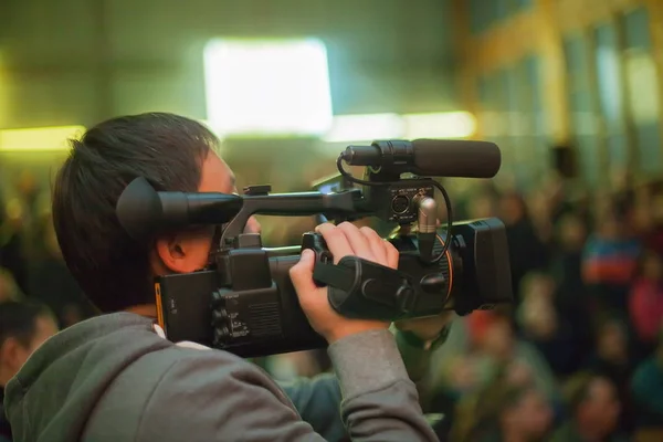 Videograaf neemt een menigte van mensen in de zaal. — Stockfoto