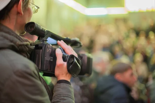 Videograaf neemt een menigte van mensen in de zaal. — Stockfoto