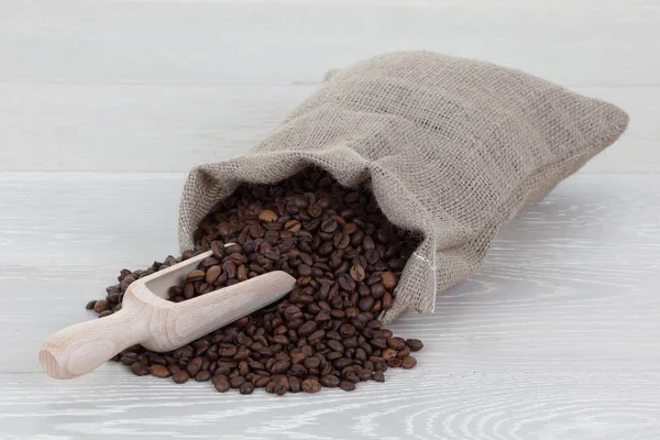 Bolso y cucharada de grano de café en madera — Foto de Stock