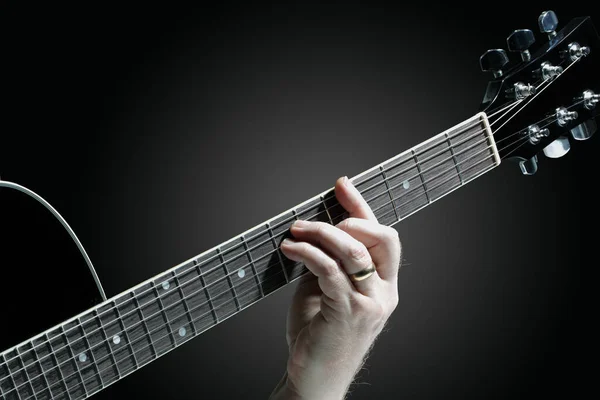 Musiker spielt Gitarre auf dunklem Hintergrund — Stockfoto