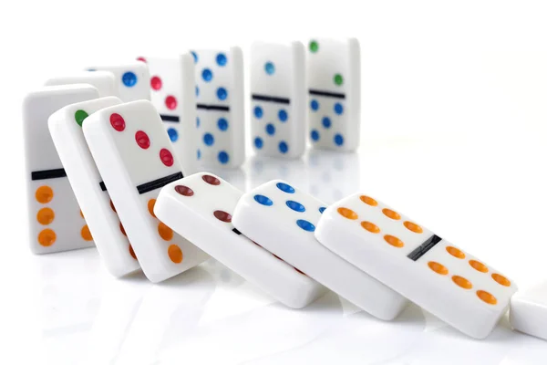 Falling colorful dominoes on a white surface — Stock Photo, Image