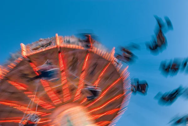 Parque de atracciones movimiento borrosa jinetes en oscilación basculante vintage retro contra el cielo azul claro . — Foto de Stock