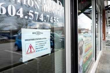Surrey, Kanada - 25 Mart 2020: Coronavirus salgını sırasında diş hekimliği bürosunun kapısına imza atın