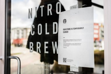 Surrey, Kanada - 25 Mart 2020: Coronavirus salgını sırasında kapandığını duyuran Starbucks kahve dükkanının ön kapısına imza atın