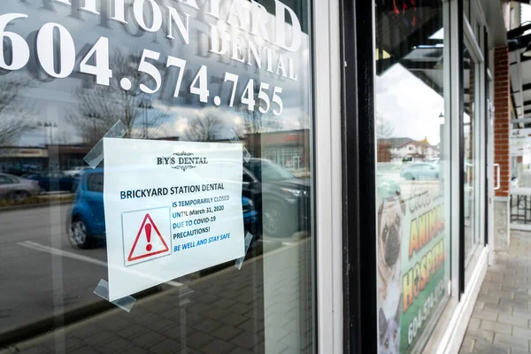 Surrey, Canada - March 25, 2020: Sign on front door of dental office announcing closure during Coronavirus pandemic — Stock Photo, Image