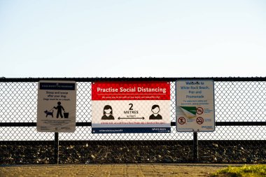 White Rock, Kanada - 25 Mart 2020: Toplumsal Mesafe Bildirisi ve halka açık Gezinti Geçidi 'nde çitlere asılan genel tabelalar