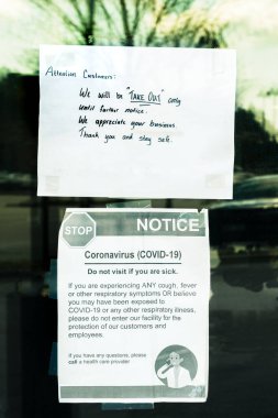 Coronavirus salgını sırasında restoranın kapısına bantlanmış sadece paket servisi ve Covid-19 sağlık tabelaları.
