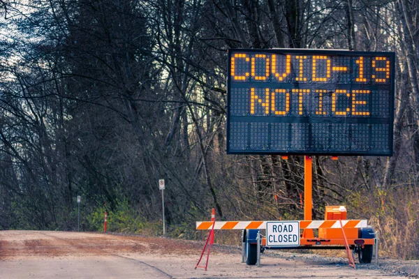 Przenośny pomarańczowy tablicę komunikatów drogowych szeroki Covid-19 powiadomienia o zamknięciu drogi Zdjęcia Stockowe bez tantiem