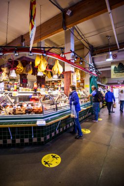 Vancouver, Kanada - 7 Nisan 2020: Coronavirus salgını sırasında insanlar Granville Island Market 'ten et ürünleri satın alıyorlar