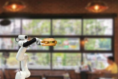 Akıllı robot yiyeceği restorantta hamburger tutuyor. Fütürist robot otomasyonu verimliliği artırıyor.