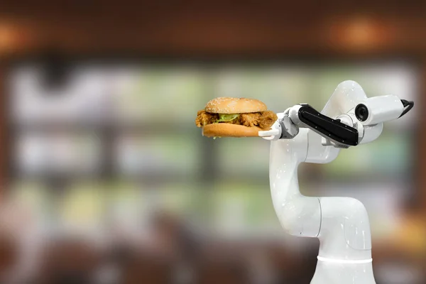 Akıllı robot yiyeceği restorantta hamburger tutuyor. Fütürist robot otomasyonu verimliliği artırıyor.