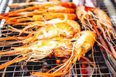 Restoranın karides ızgara deniz ürünleri ve arka planda başka yemekler.