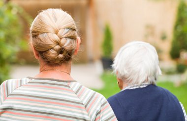 Genç bakıcı parkta yaşlı kadın ile yürüme
