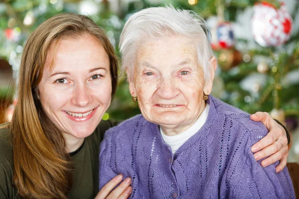 Mujer anciana y joven cuidadora — Foto de Stock