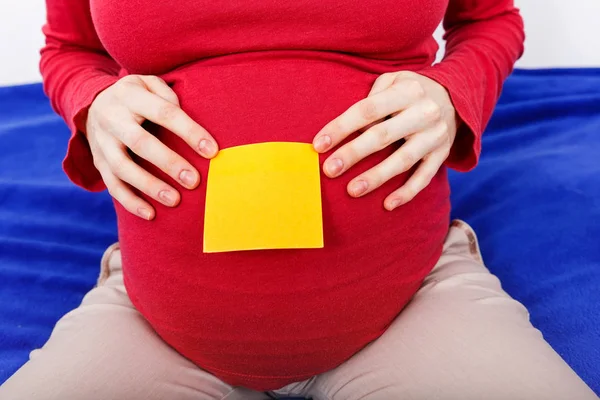 妊娠中の女性の腹上に付箋 — ストック写真