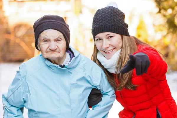 Mujer anciana y joven cuidadora — Foto de Stock