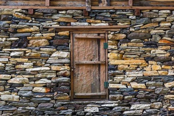 Kamenná zeď a dřevěné dveře — Stock fotografie