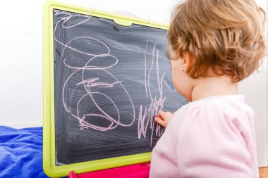 Küçük kız yazı tahtası üzerinde çizim