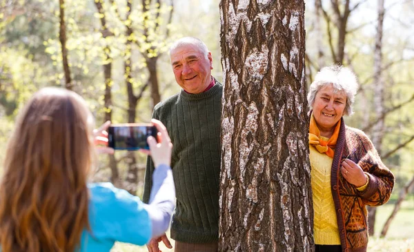 Jeune aidant prenant une photo de couple âgé — Photo