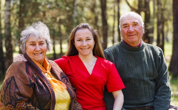 Elderly couple and young caregiver — Stock Photo, Image