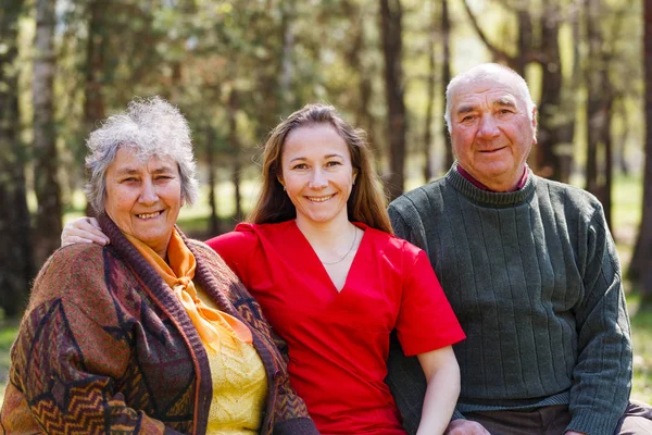 Ältere Ehepaare und junge Pfleger — Stockfoto