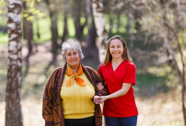 高齢の女性と若い介護者 — ストック写真