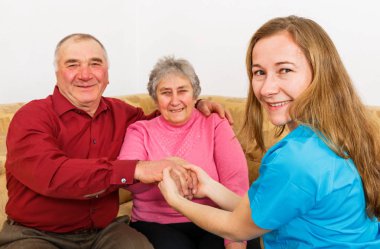 Gülümseyen yaşlı çift ve genç caregiver