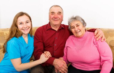 Gülümseyen yaşlı çift ve genç caregiver